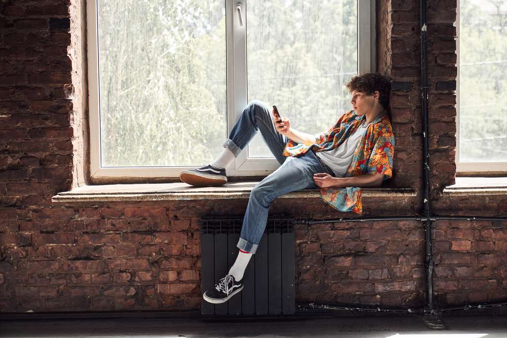 Model relaxing on the window sill during photoshoot